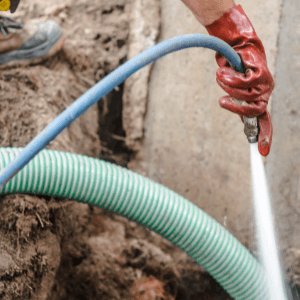 septic tank cleaning Birmingham - 17 Signs That You Need To Get Your Septic Tank Cleaned In Birmingham - a septic tank specialist cleaning a septic tank with water sprayed from hose